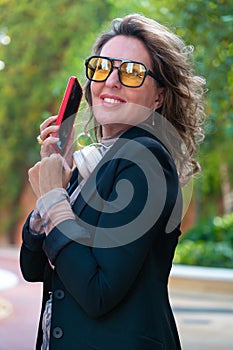 Vertical Portrait beautiful business woman smiling talking on smartphone outdoors.