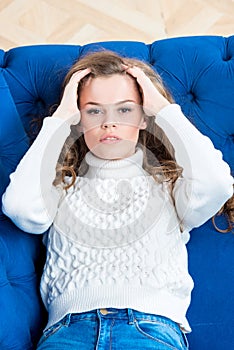 Vertical portrait of a beautiful girl posing on the sofa in the