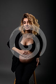 Vertical portrait of a beautiful pregnant woman in a pantsuit