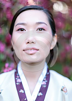 Vertical portrait of beautiful young adult girl with clean skin and delicate make-up, dressed in a traditional folk costume and photo