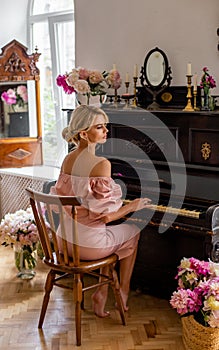 Vertical portrait of a charming blonde playing the piano