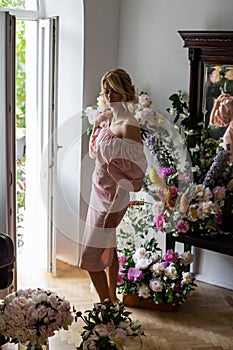 Vertical portrait of a charming blonde by the window