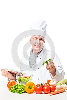 Vertical portrait of a cook at the table with book