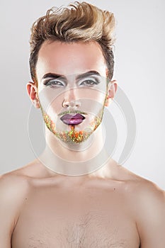 Vertical portrait of cutie young gay model with makeup and multi