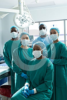 Vertical portrait of diverse group of surgeons ready for surgery in operating theatre, copy space