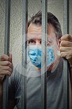 Vertical portrait of an elderly inmate in a blue protective face mask.