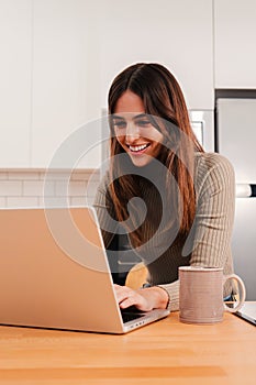 Vertical portrait of entrepreneur woman working online on laptop at home office. Happy young girl studing with a