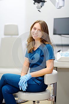 Vertical portrait of female ENT doctor during appointment of patient in medical office. Professional otolaryngologist is on