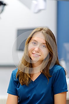 Vertical portrait of female ENT doctor during appointment of patient in medical office. Professional otolaryngologist is on