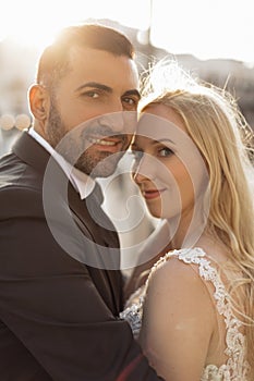 Vertical portrait glad and cheerful romantic married couple, blond woman and black-haired man after wedding, overdressed