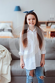 vertical portrait of happy 10 years old kid or preteen girl relaxing at home