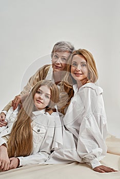 Vertical portrait of happy three generations of women in studio