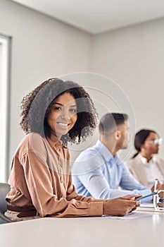 Vertical portrait of happy young African business woman at office meeting.