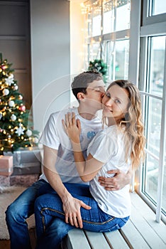 Vertical portrait of husband and wife man and woman at home on Christmas eve. Happy family girlfriend and boyfriend near Christmas