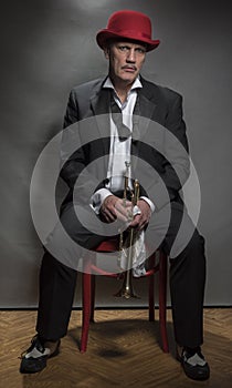 Vertical portrait image of a mature jazz man with a trumpet