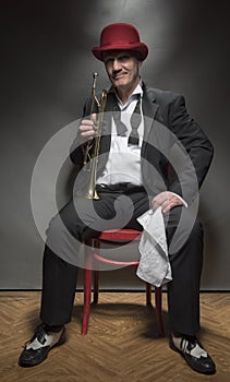 Vertical portrait image of a mature jazz man with a trumpet