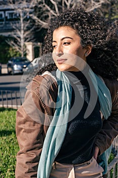 Vertical portrait of a Latin woman with curly hair with a melancholic look