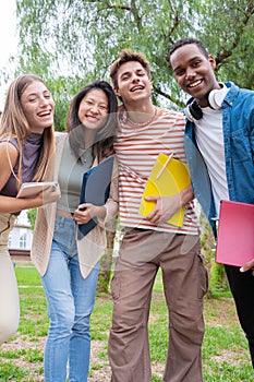 vertical portrait multiracial group of students smiling looking at camera outdoors.