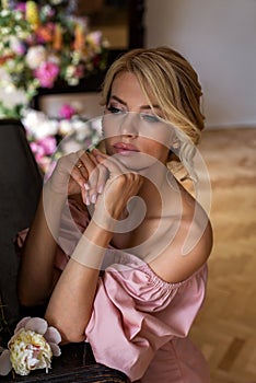 Vertical portrait of a pensive blonde with flowers