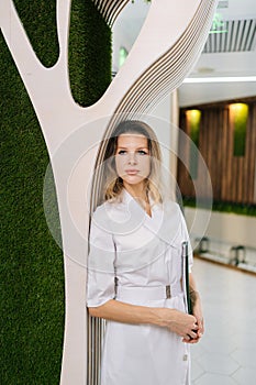 Vertical portrait of professional female doctor or nurse in medical coat holding clipboard with with medical report