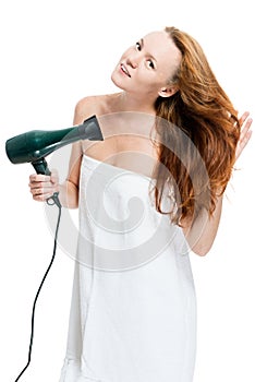 Vertical portrait of a red-haired woman with a hairdryer