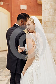 Vertical portrait of romantic married couple, after wedding, overdressed, stand outside. Italy vacation, travel abroad
