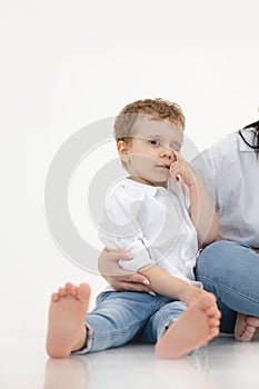 Vertical portrait of sad, crying little kid, boy with close eye. Bad and negative emotions, stress and upsetting child