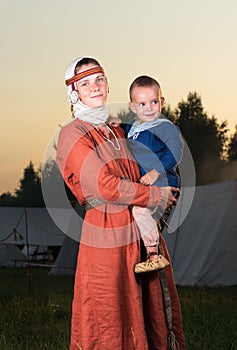 Vertical portrait of a Slavic woman with a child in costume history