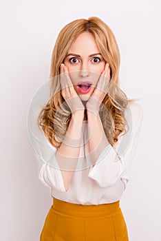 Vertical portrait of surprised young woman with opened mouth standing against white background
