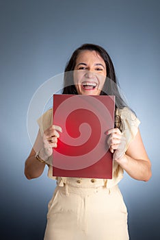 Vertical portrait of young businesswoman, lawyer, showing her business folder