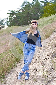 Vertical portrait of a young perky girl on a background of summer nature