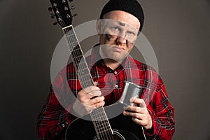 Vertical portrait of a young street musician who is upset. earning concept on the city streets