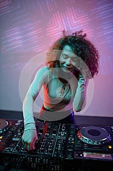 Vertical portrait of young woman as DJ