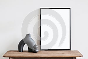 Vertical poster art mockup with black frame and trendy vase on empty wall background, Template for artwork, painting or photo