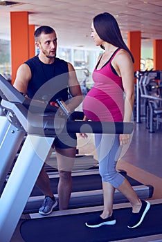 Pregnant woman during the third trimester running on treadmill photo