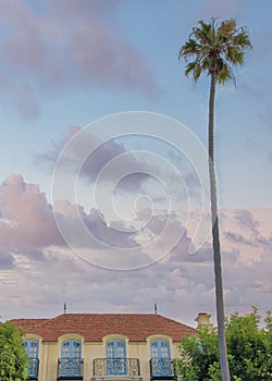 Vertical Puffy clouds at sunset Old mediterranean mansion at La Jolla, California with vines on