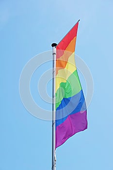 vertical rainbow or lgbtq pride flag on flagpole