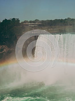 Vertical of a rainbow over Niagara Falls on a sunny day