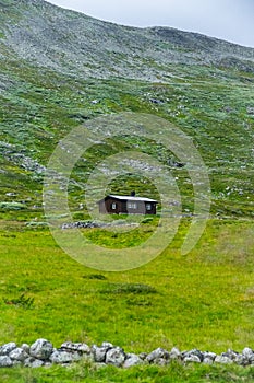 Vertical realistic view of a single house on a mountain in summer Norway