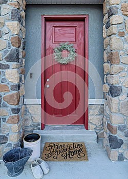 Vertical Red front door with wreath and portico with stone columns at the home entrance
