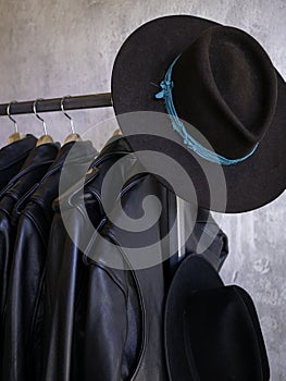 Vertical: Retail fashionable coat rack display with wide brimmed hat.