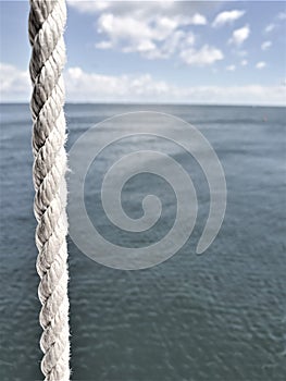 Vertical rope with bokeh effect ocean in background