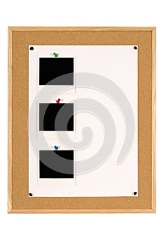 Vertical row of three Polaroid photo frames on notice board with white poster paper copy space