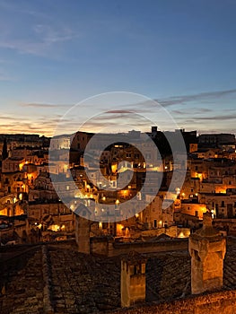 Vertical of the Sassi di Matera cave dwellings under the blue sky at night in Italy photo