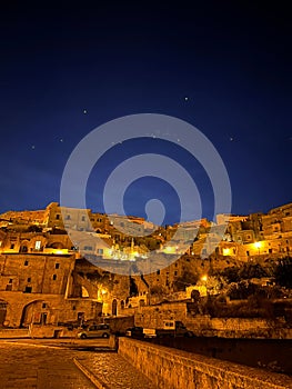 Vertical of the Sassi di Matera cave dwellings under the starry sky at night in Italy photo