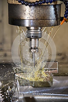 The vertical scene of CNC milling machine cutting the  mold parts with oil coolant method.