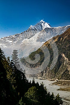 Vertical scenic photo of Gandaki river valley and snowcapped mountain peak, Himalayas