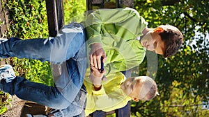 Vertical Screen: One boy trying take smartphone from another