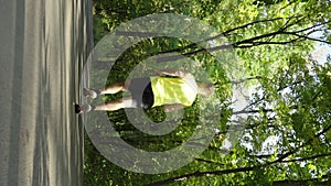 Vertical Screen: Slow motion man jogging in summer park