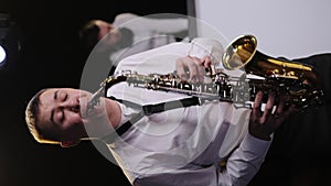 Vertical Screen Video of Saxophonist Play on Golden Saxophone. Cool saxophone player performing a solo on stage